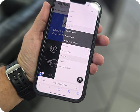 A person using Carvana.com on their phone to search for vehicles that are eligible for the EV tax credit